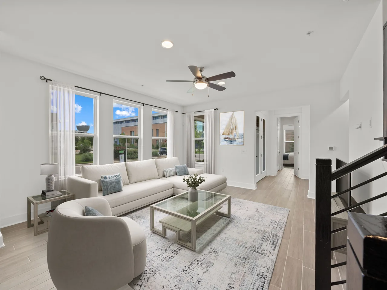 The same living room after virtual staging — sofa, armchair, coffee table, rug and wall art